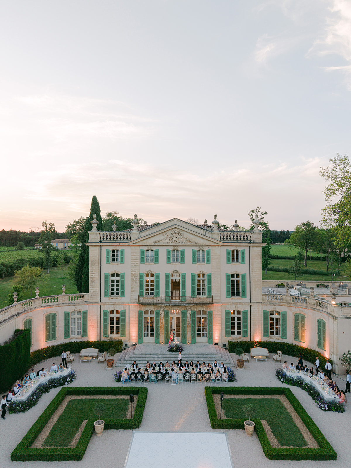 Aerial sunset view of the Château de Tourreau courtyard dinner and floral layout created by Capucine Atelier Floral.