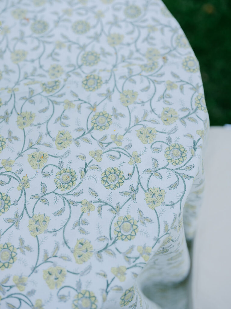Close-up of the blue and green botanical-patterned tablecloth used for the elegant garden cocktail tables.