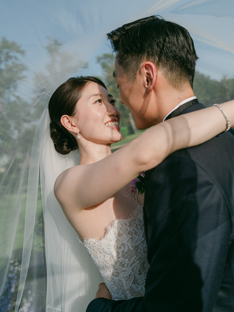 Close-up of Casey smiling at James beneath her veil during their romantic Château de Tourreau wedding.