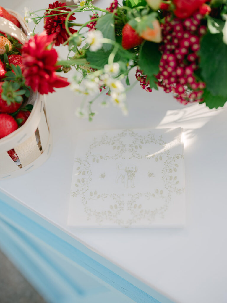 Personalised napkin illustrated with the couple’s dog, framed by strawberries and red flowers at the Bao Bar.