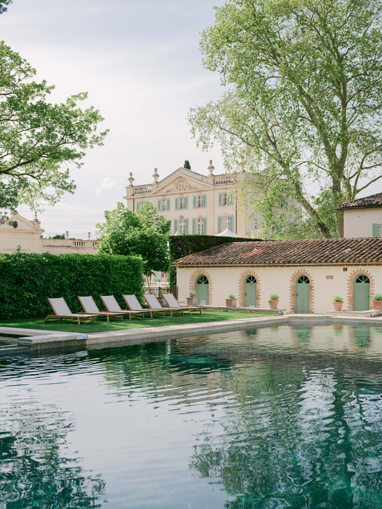 Reflecting pool and manicured gardens with Château de Tourreau visible through the trees in Provence.