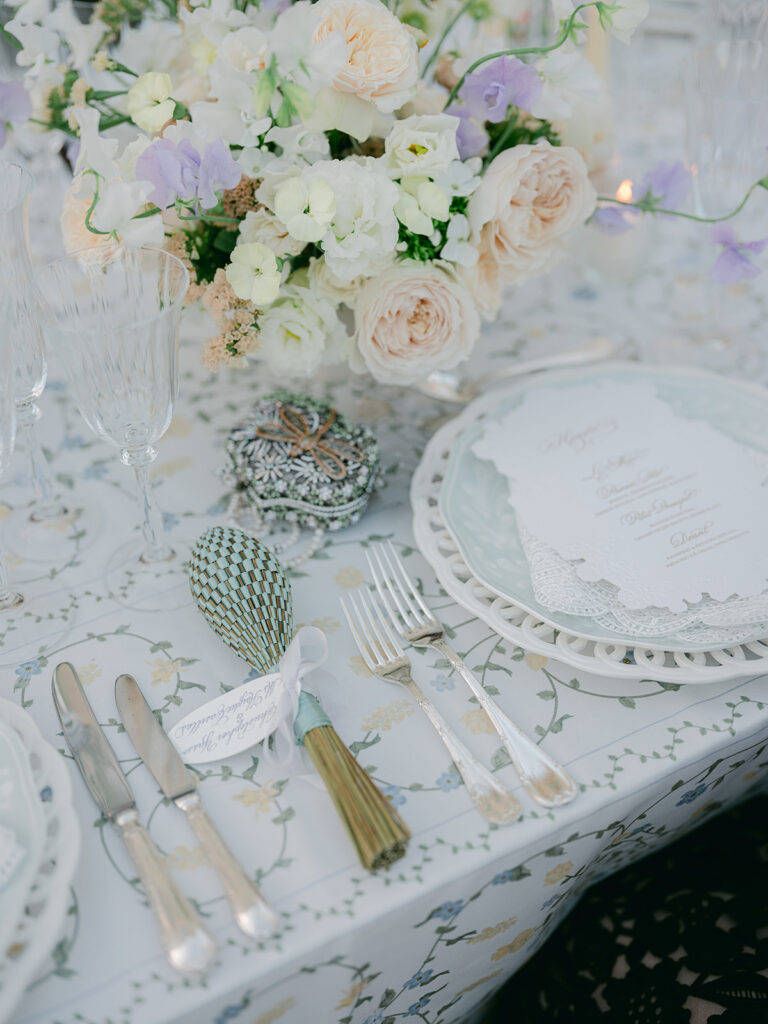 Layered white plates, crystal glassware, silver cutlery and pastel flowers form a luxury place setting by Capucine Atelier Floral.