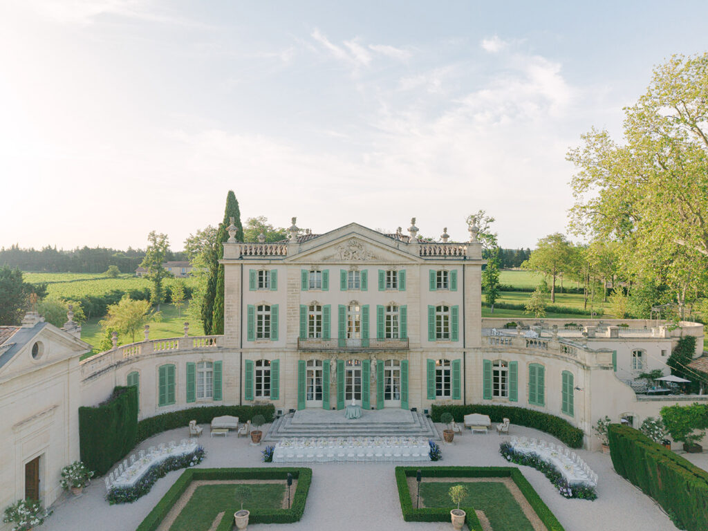 Aerial view of the luxury outdoor dinner layout and floral tablescape by Capucine Atelier Floral in the courtyard of Château de Tourreau.