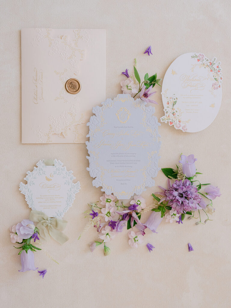 Luxury wedding stationery with lilac flowers, scalloped paper details and a hand-painted floral design.