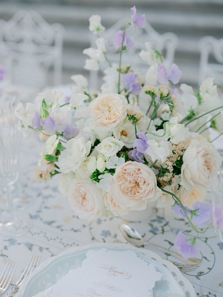 Garden roses, sweet peas and airy pastel flowers create an elegant dinner centerpiece by Capucine Atelier Floral.