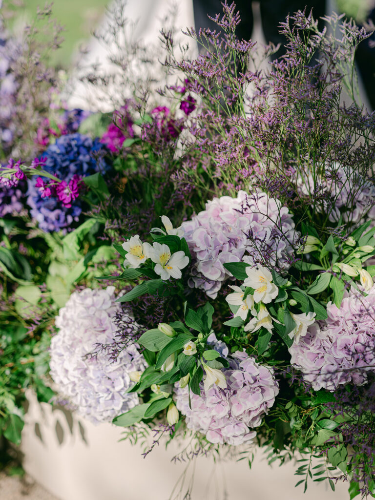 Close-up of purple hydrangeas, white alstroemeria and airy foliage in Capucine Atelier Floral's ceremony design.