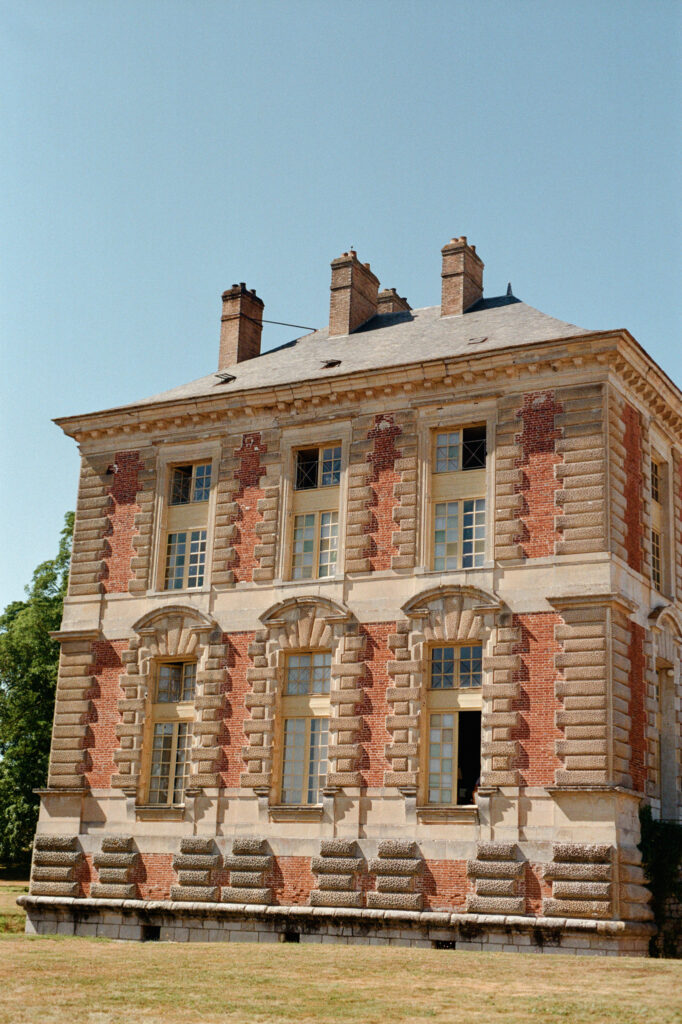 Historic brick-and-stone façade of Château de Vallery, venue for Kaylin and Paul’s Indian wedding in France.