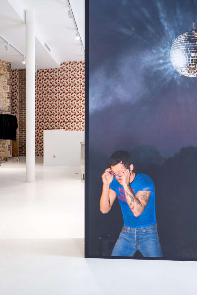 Large Harry Styles album artwork with a disco ball displayed inside the Paris launch venue.