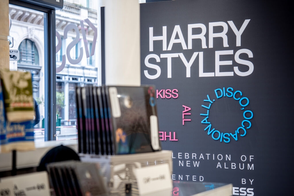 Harry Styles vinyl records in front of the Kiss All the Time. Disco, Occasionally. launch sign in Paris.