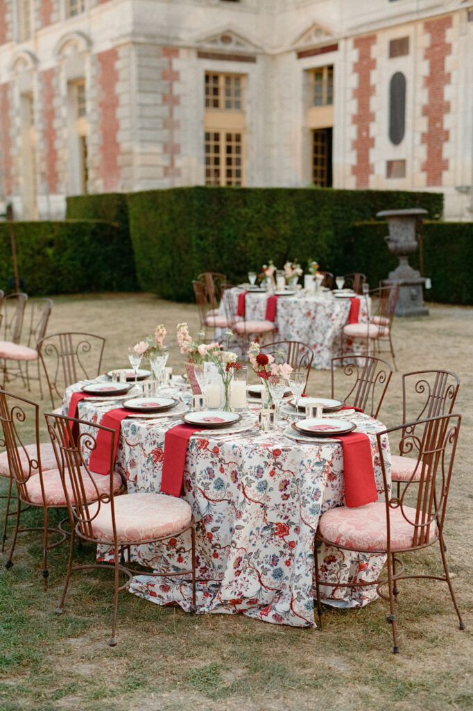 Outdoor Indian wedding reception tables with colorful floral design by Capucine Atelier Floral beside Château de Vallery.