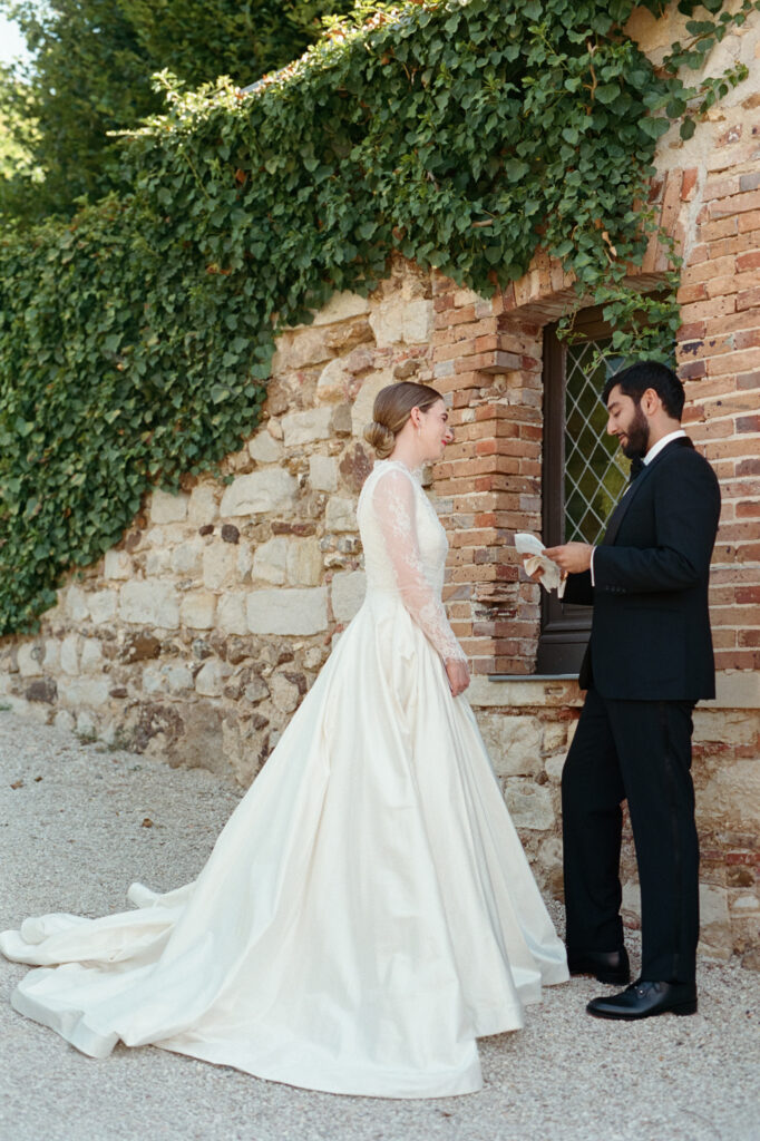 Kaylin and Paul share a quiet moment beside the ivy-covered stone walls of Château de Vallery.